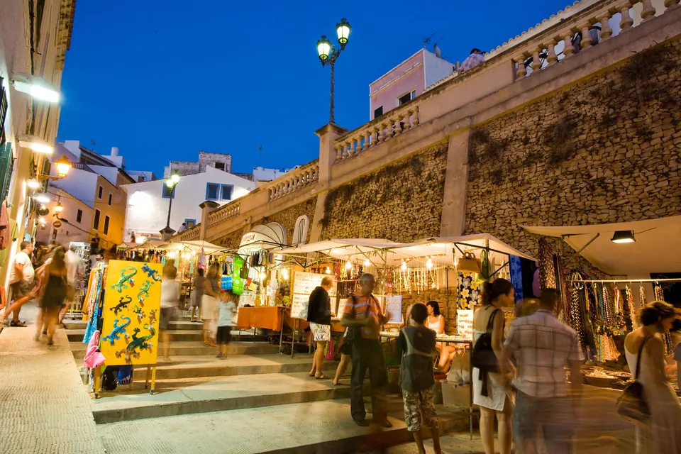 Mercadet nocturn amb parades en un carrer vora una escalinata