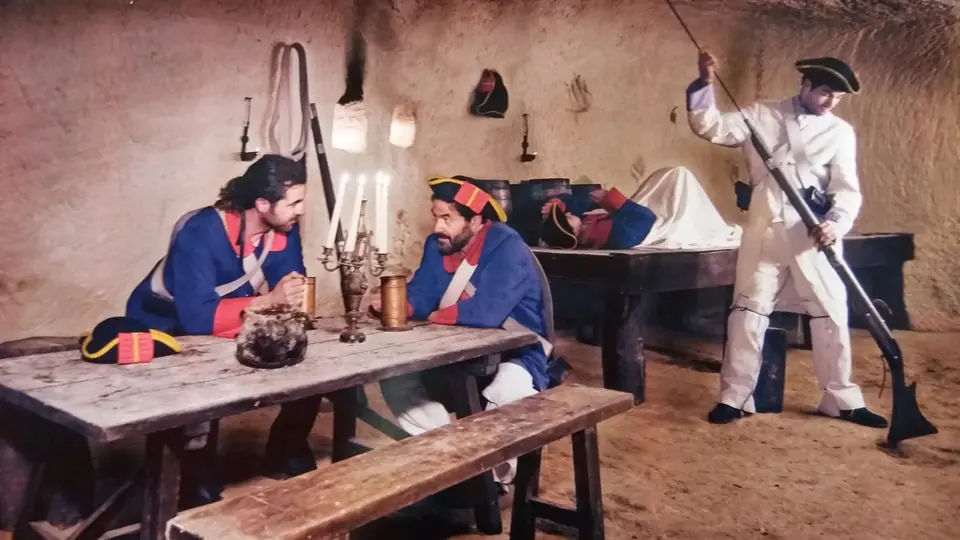 Tres figurants amb uniformes del segle XVIII en una estança de pedra