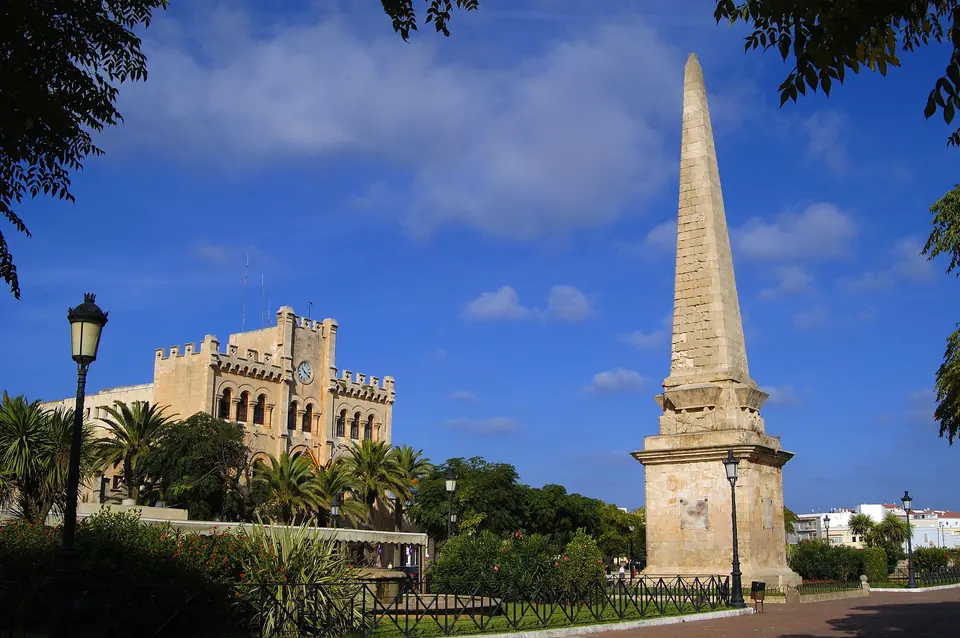 Obelisc de pedra al costat d’un edifici amb merlets