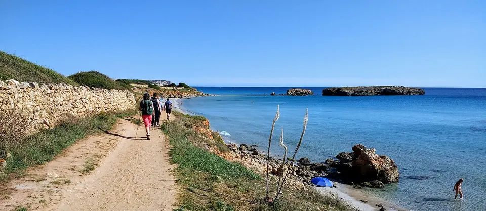 Camí de terra vora la costa amb excursionistes