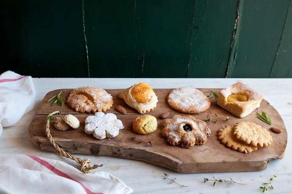 Assortiment de dolços i pastes menorquines sobre una taula de fusta
