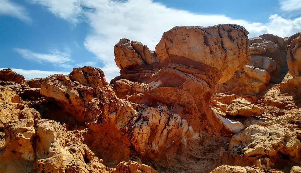 Formazioni di roccia rossastra modellate dall’erosione sotto un cielo azzurro