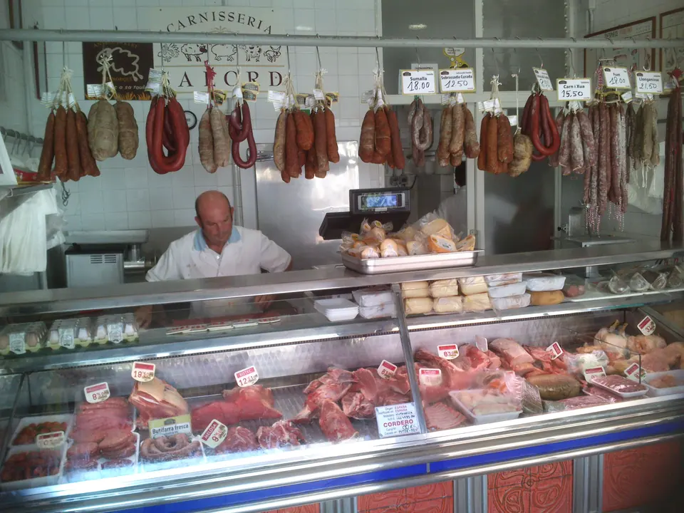 Carnisseria amb embotits penjats i una vitrina de carn