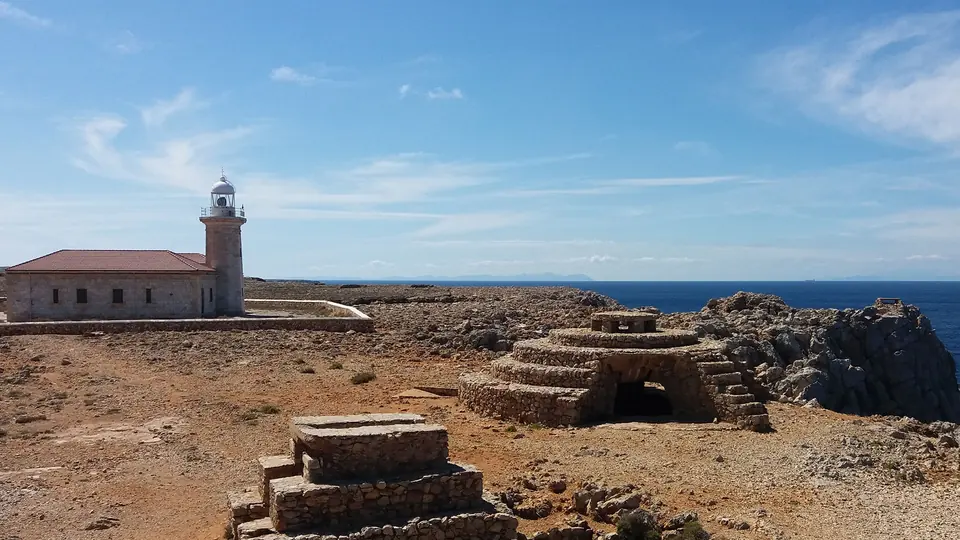 Far i edificis sobre un terreny rocós vora el mar