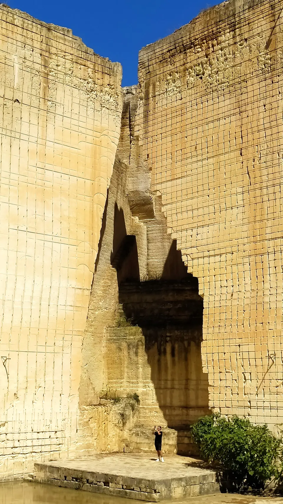 Alta paret vertical d’una pedrera de pedra calcària clara