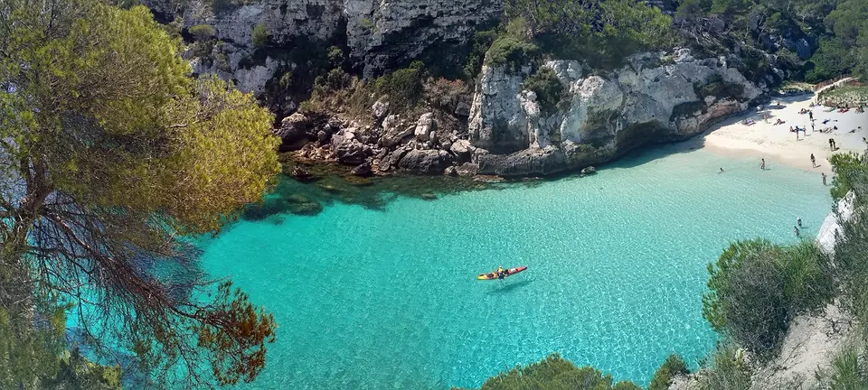 Macarelleta: cala d’aigües turquesa amb una barca