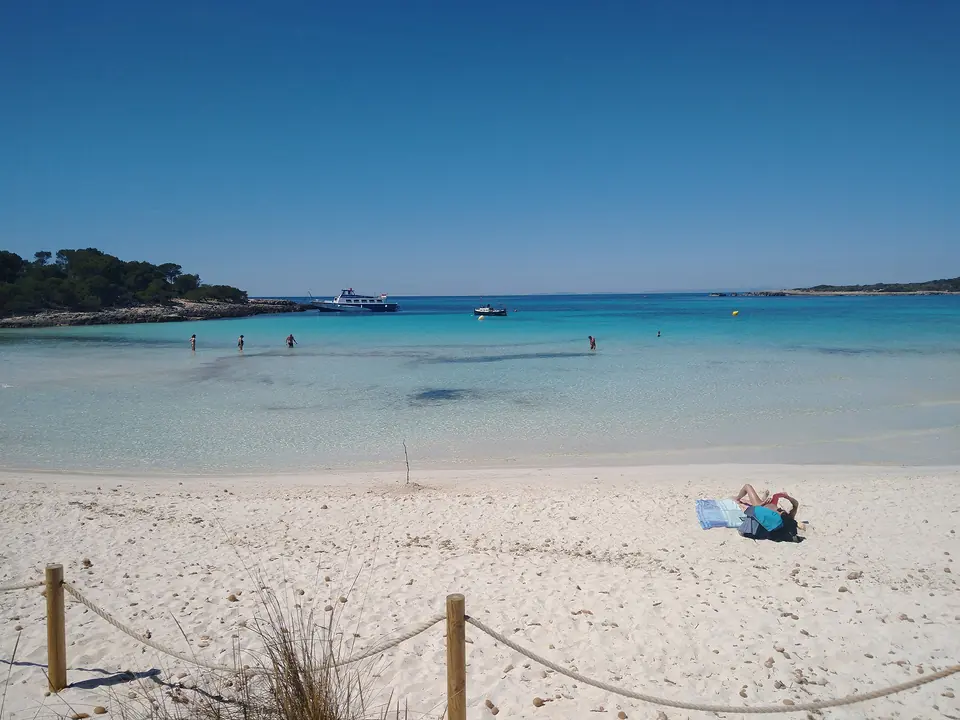 Son Saura: platja de sorra blanca amb cordes i aigües poc profundes